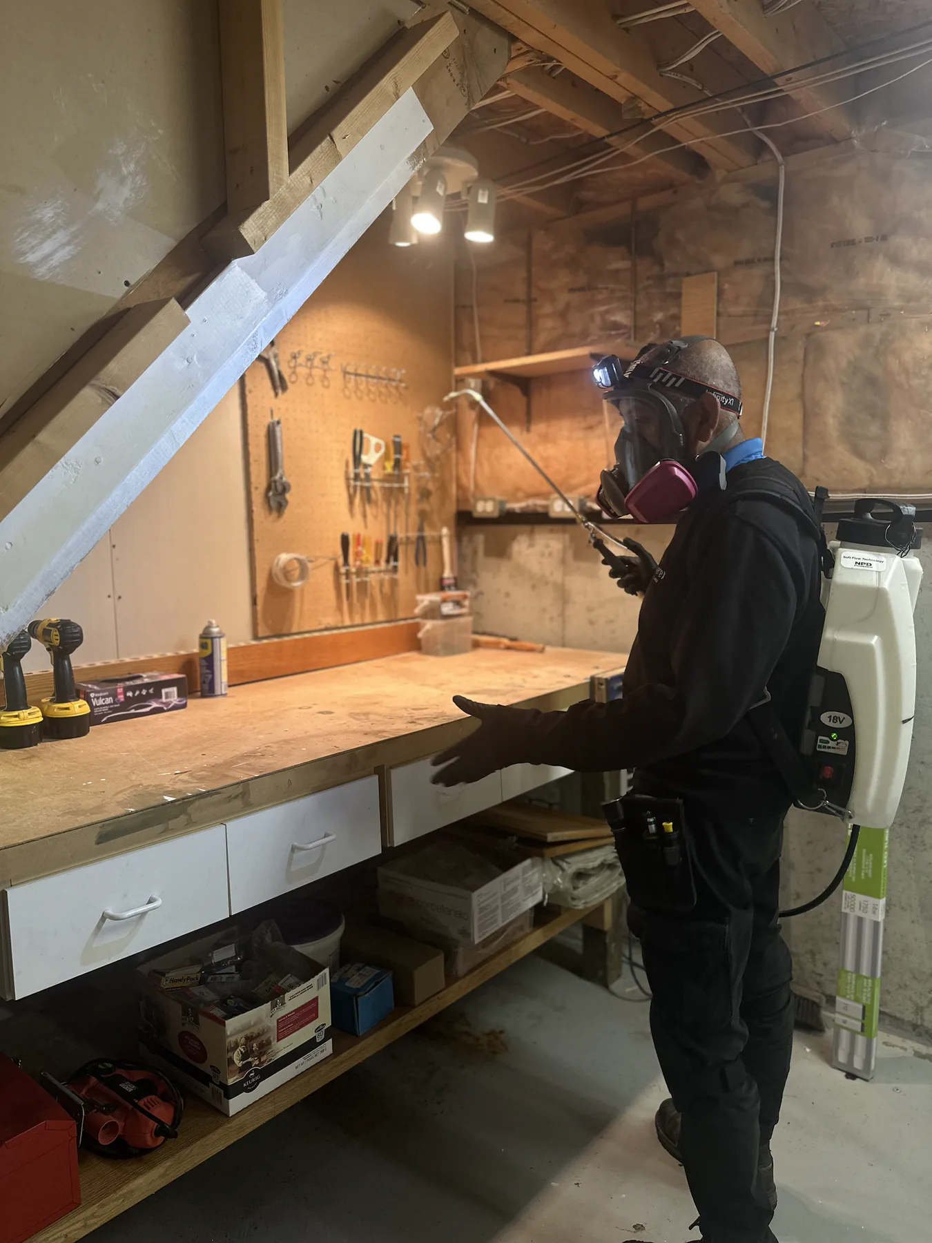 Pest control technician wearing a respirator and backpack application system