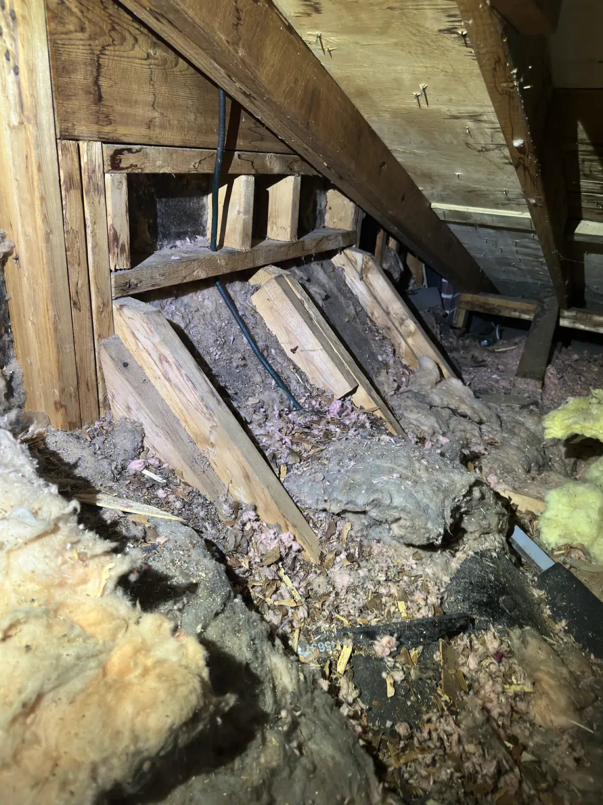 Broken and deteriorated wood inside an opened roof cavity