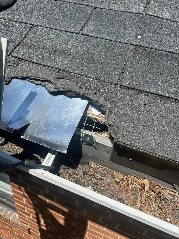 Open section at the roof edge above a gutter and brick wall